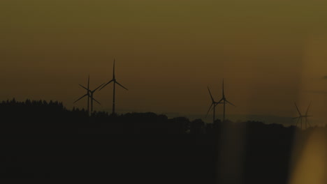 pan over wind turbines in the highlands at sunset with beautiful warm and yellow light