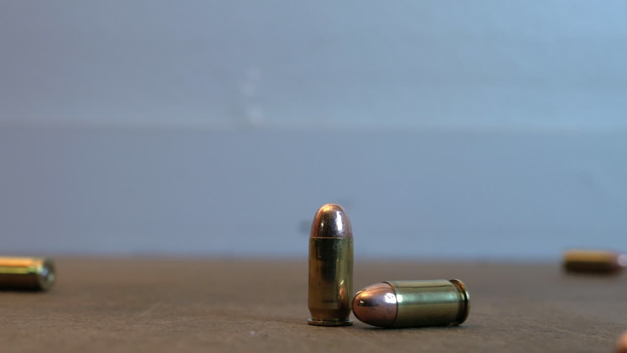45 caliber pistol ammo rolling on a table