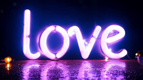 glowing neon sign spelling love illuminates a wet surface, creating a romantic atmosphere with reflections in purple and pink hues