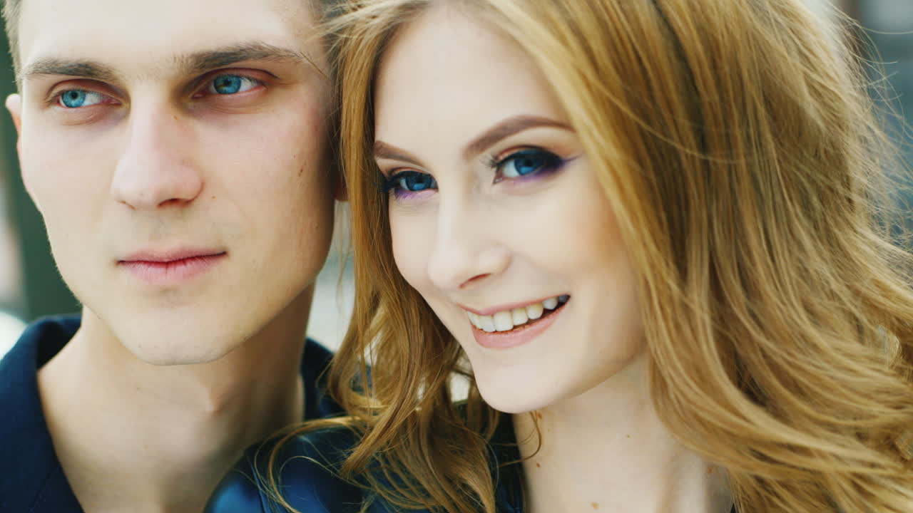 pareja romántica sonriendo alegremente tienen entre 20 y 25 años la chica hermosos ojos azules