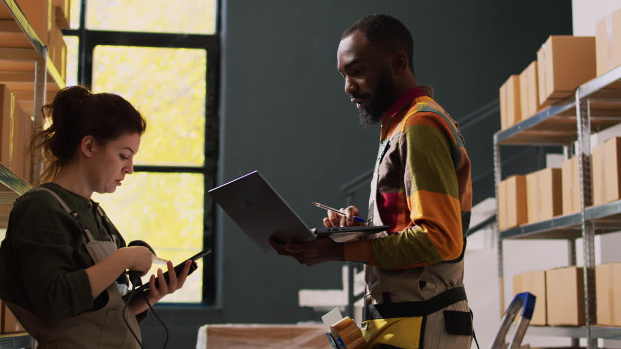 Warehouse employees checking inventory with laptop and scanner