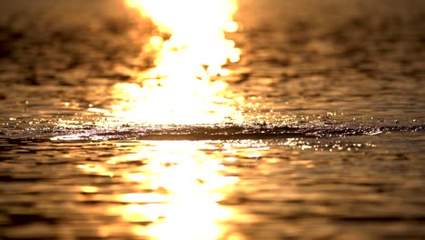 slow motion of water splashing on lake surface against sunlight