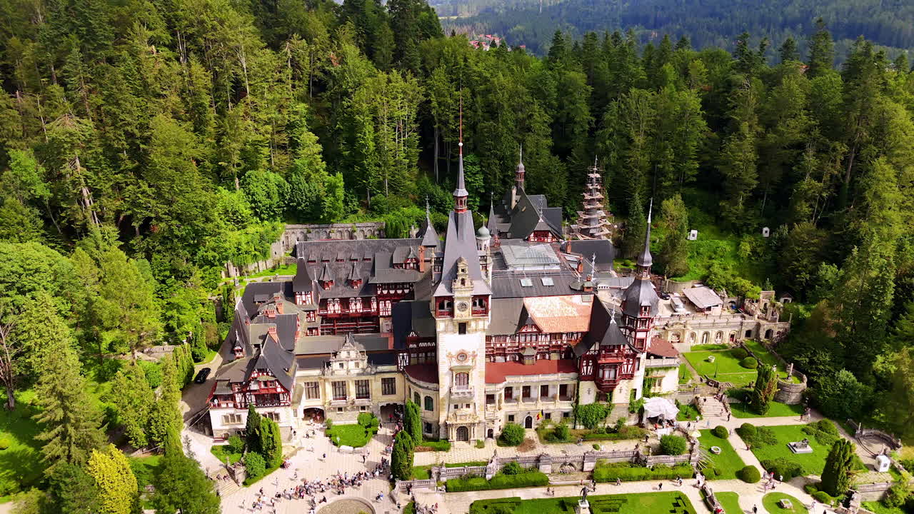 Wonderful century-old castle in the lush greenery. Drone footage above the Pele? Castle in the Carpathian Mountains, Romania