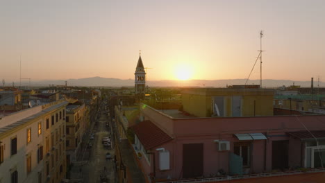 Beautiful-morning-footage-of-rooftops-and-tower-against-rising-sun.-Town-development-in-urban-borough.-Rome,-Italy