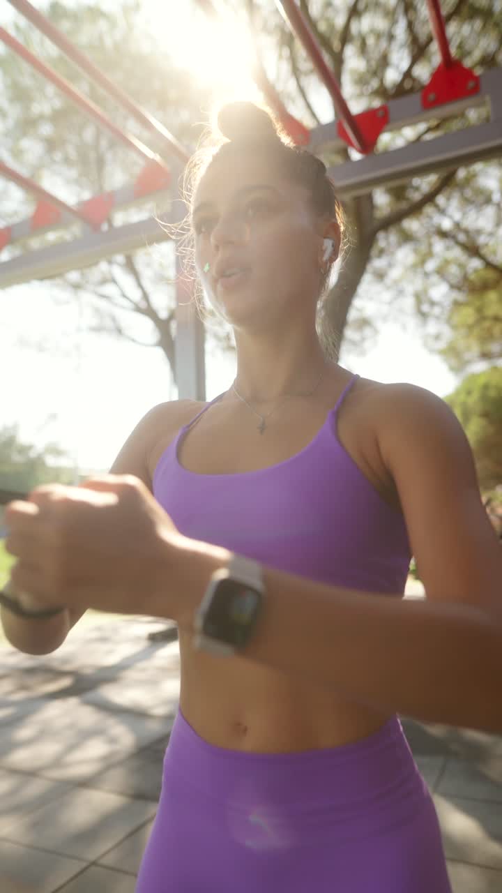 A young woman exercising outdoors in purple athletic wear