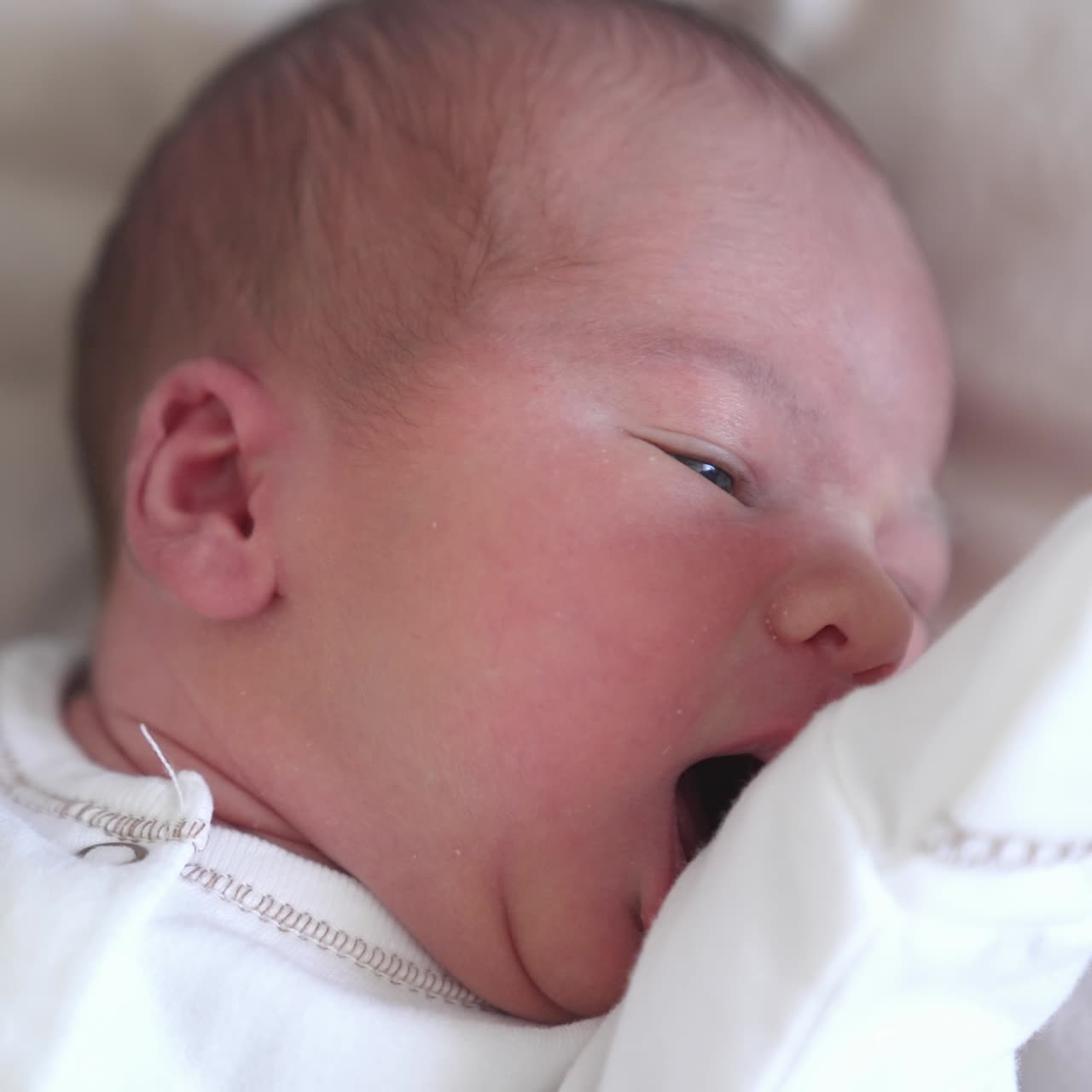 Lindo retrato de um bebê recém-nascido. Rosto de um bebê deitado em uma cama. Criancinha faminta procurando a mãe. Criancinha fofa