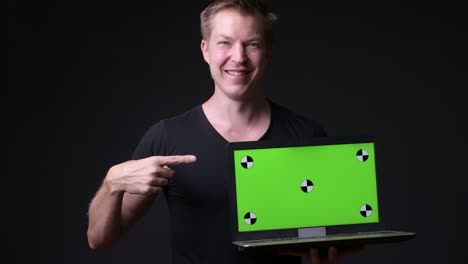 man holding laptop with chroma key green screen