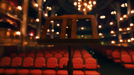 empty stage with music stand and red velvet seats