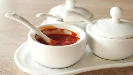 white serving dishes with tomato sauce