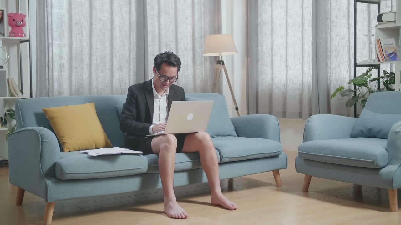 소파에서 노트북으로 일하는 남자