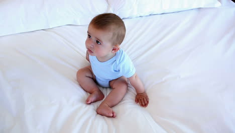 un niño lindo sentado en la cama