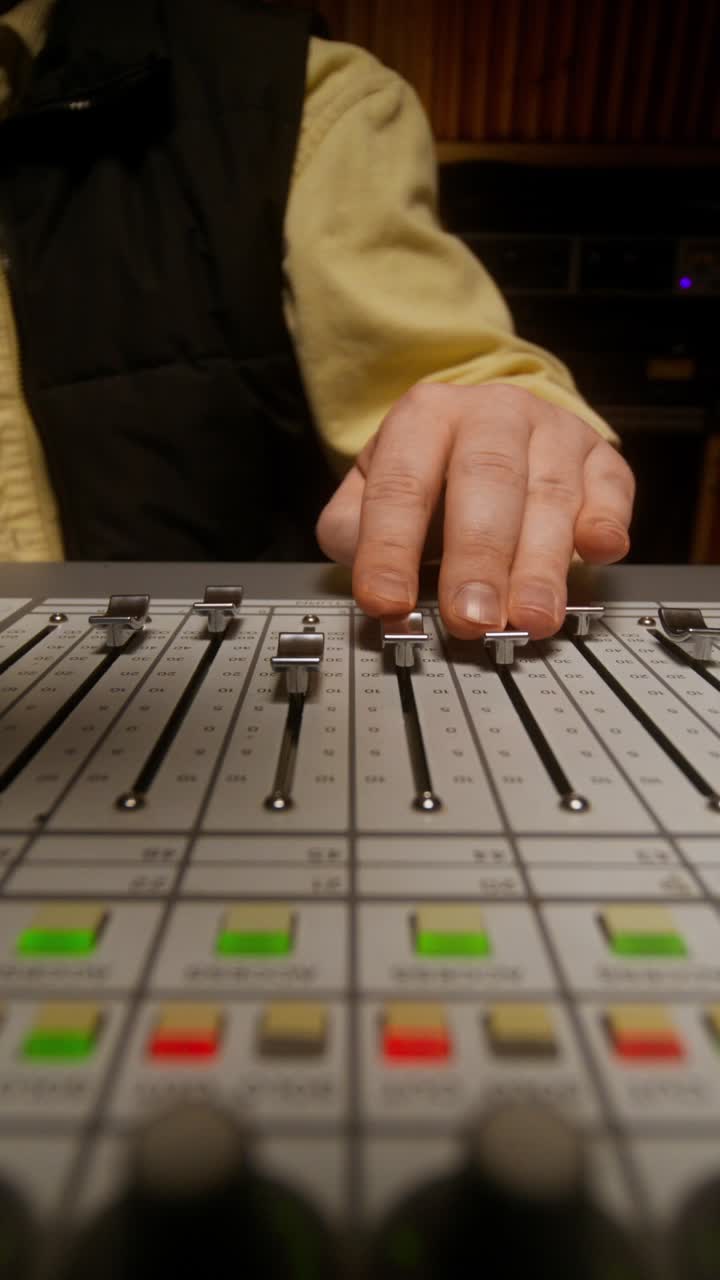 Audio Engineer Working on a Mixing Board