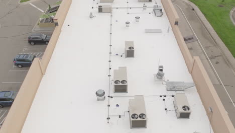 HVAC-condenser-units-at-the-rooftop-of-building,-aerial-jib-shot