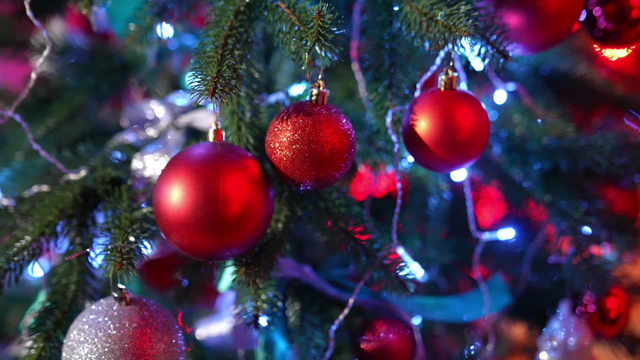Christmas tree. Beautiful New year fir tree with bright Christmas balls and ribbons. Close-up. Festive atmosphere at winter holidays.