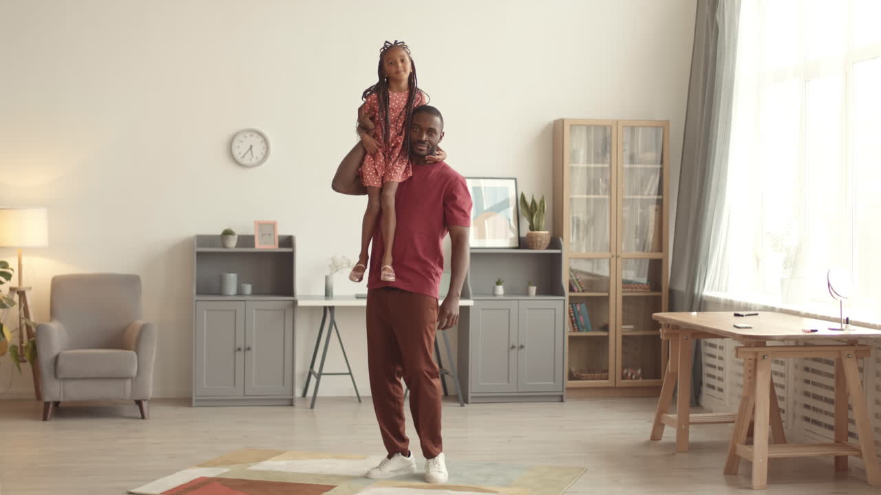 Mann danser med datter på skulderen