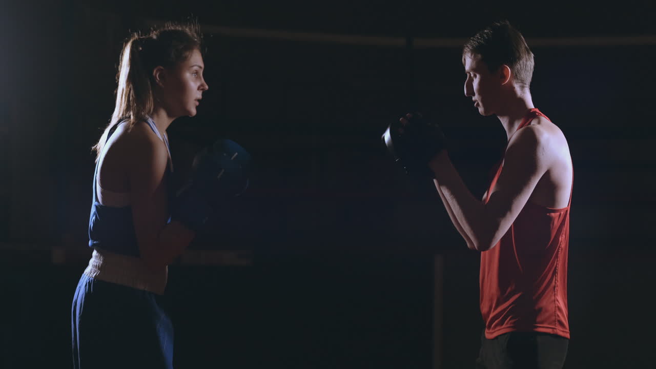 kickboxer mujer atleta entrenadora de kickboxing entrenando amigas de acondicionamiento físico boxeando golpeando guantes de enfoque disfrutando de un entrenamiento intenso juntos en el gimnasio de cerca