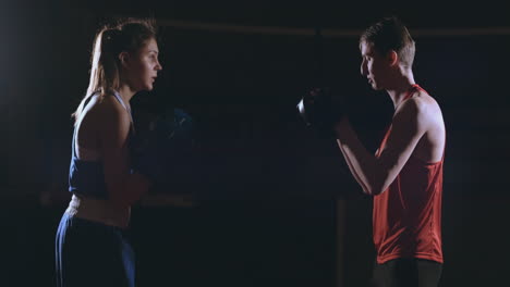 Kickboxer-Mujer-Atleta-Entrenador-De-Kickboxing-Entrenamiento-Femenino-Fitness-Amigos-Boxeo-Puñetazos-Enfoque-Guantes-Disfrutando-De-Intenso-Ejercicio-Juntos-En-El-Gimnasio-De-Cerca