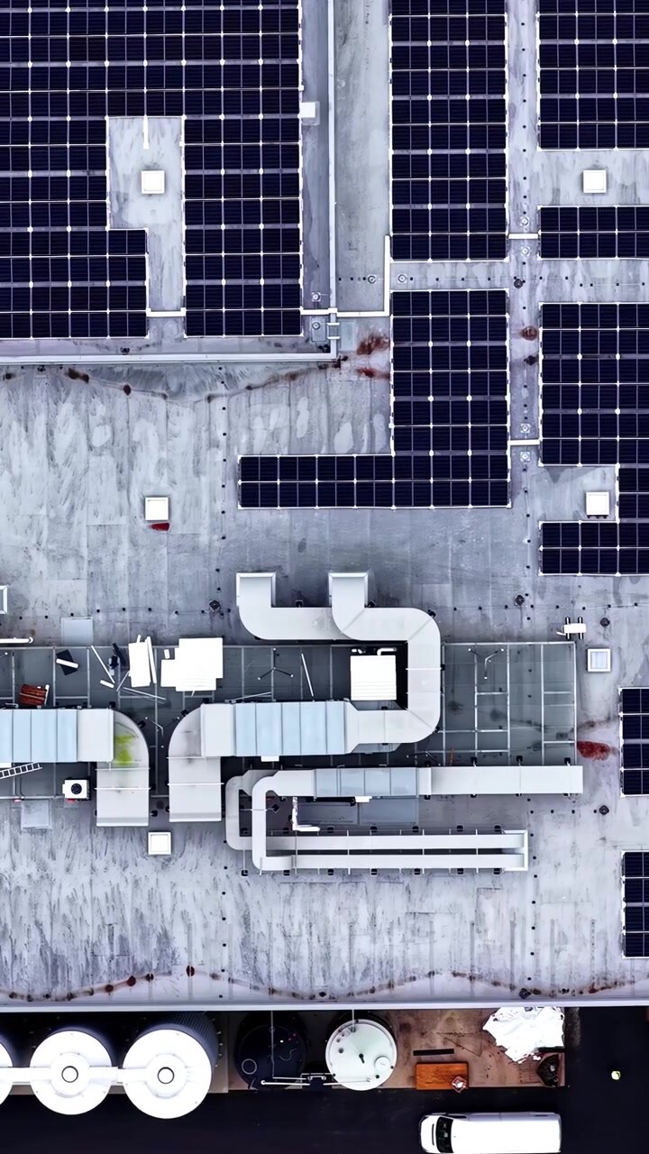 Luftfoto ovenfra af et bygningstag med solceller og klimaanlæg