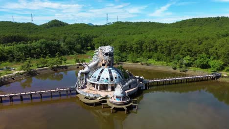 aerial spinning view of ho thuy tien abandoned water park with huge dragon structure and empty lake in hue, vietnam