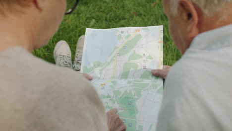 senior couple looking at a map in a park