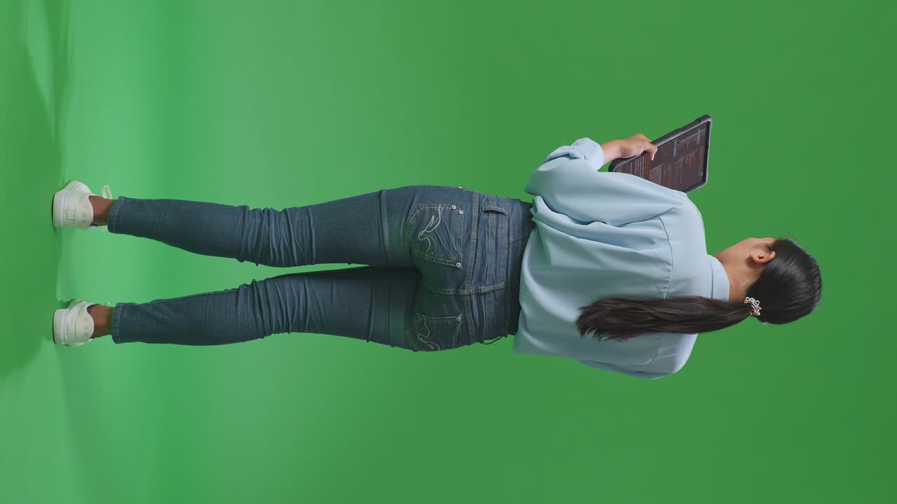 vista trasera de cuerpo completo mujer de negocios asiática usando tableta en fondo de pantalla verde en el estudio, pantalla de tableta que muestra código