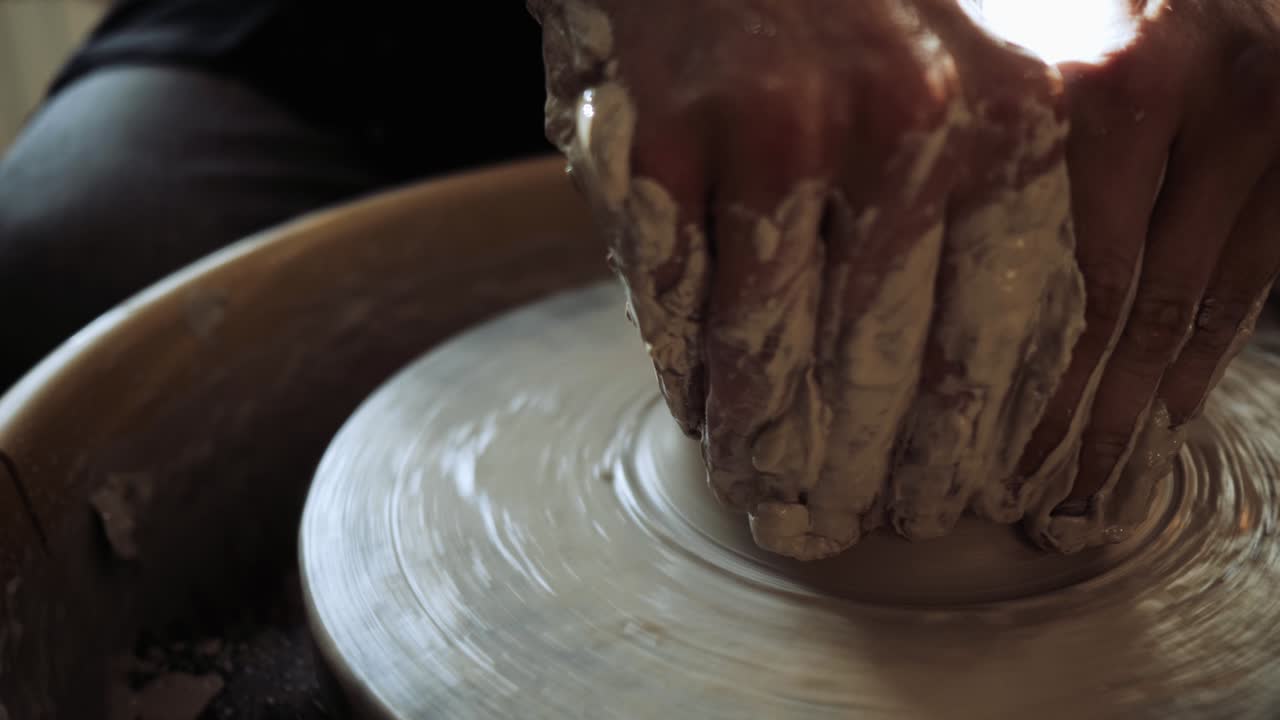 젊은 남성 도자기의 손은 도자기의 바에 일하고 도자기를 만들고 있습니다.