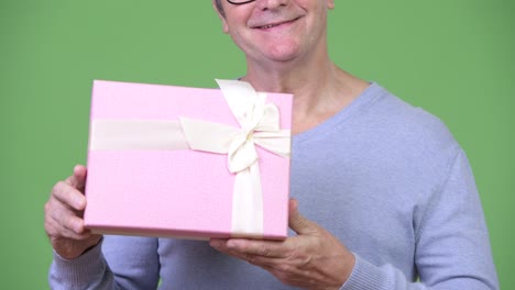 senior handsome man holding gift box