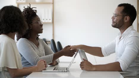 Cheerful-business-consultant-shaking-hands-with-clients