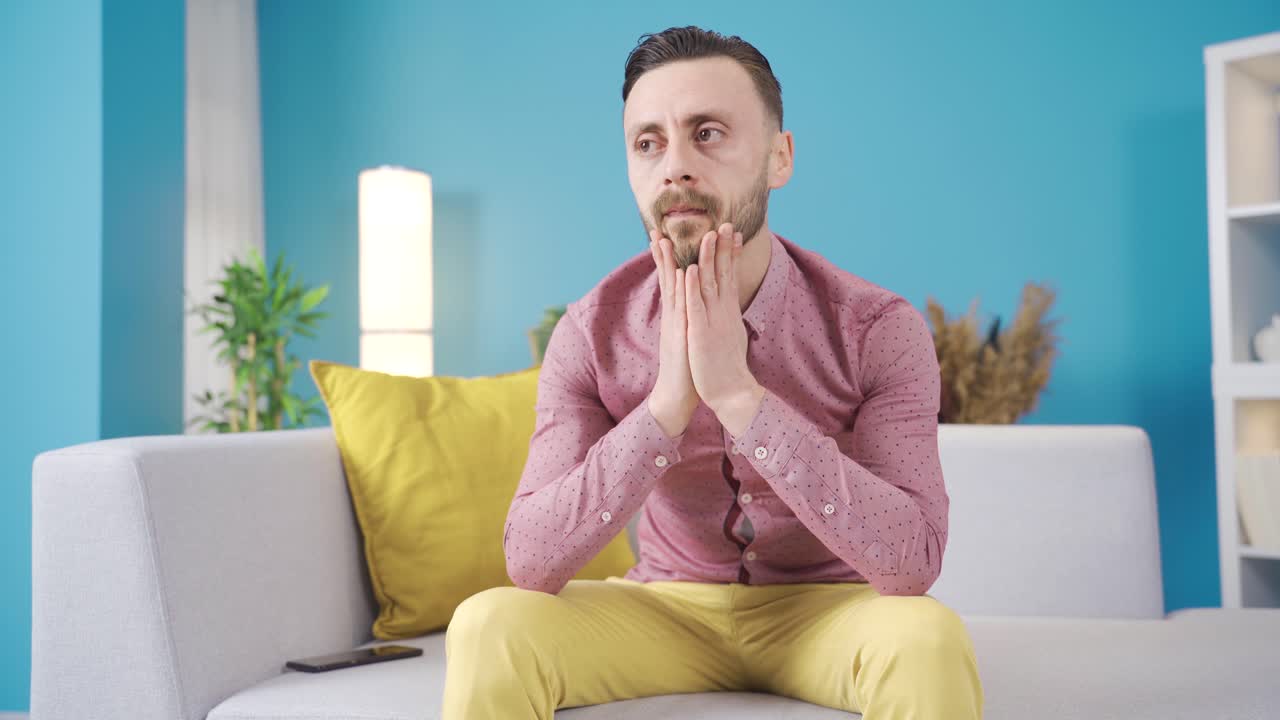 L'uomo usa il telefono a casa e si sente stressato e arrabbiato.