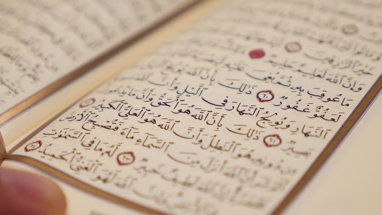 una toma en movimiento en medio círculo que muestra a una persona leyendo un corán