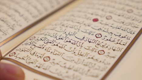 A moving shot in a half circle showing a person reading a Quran