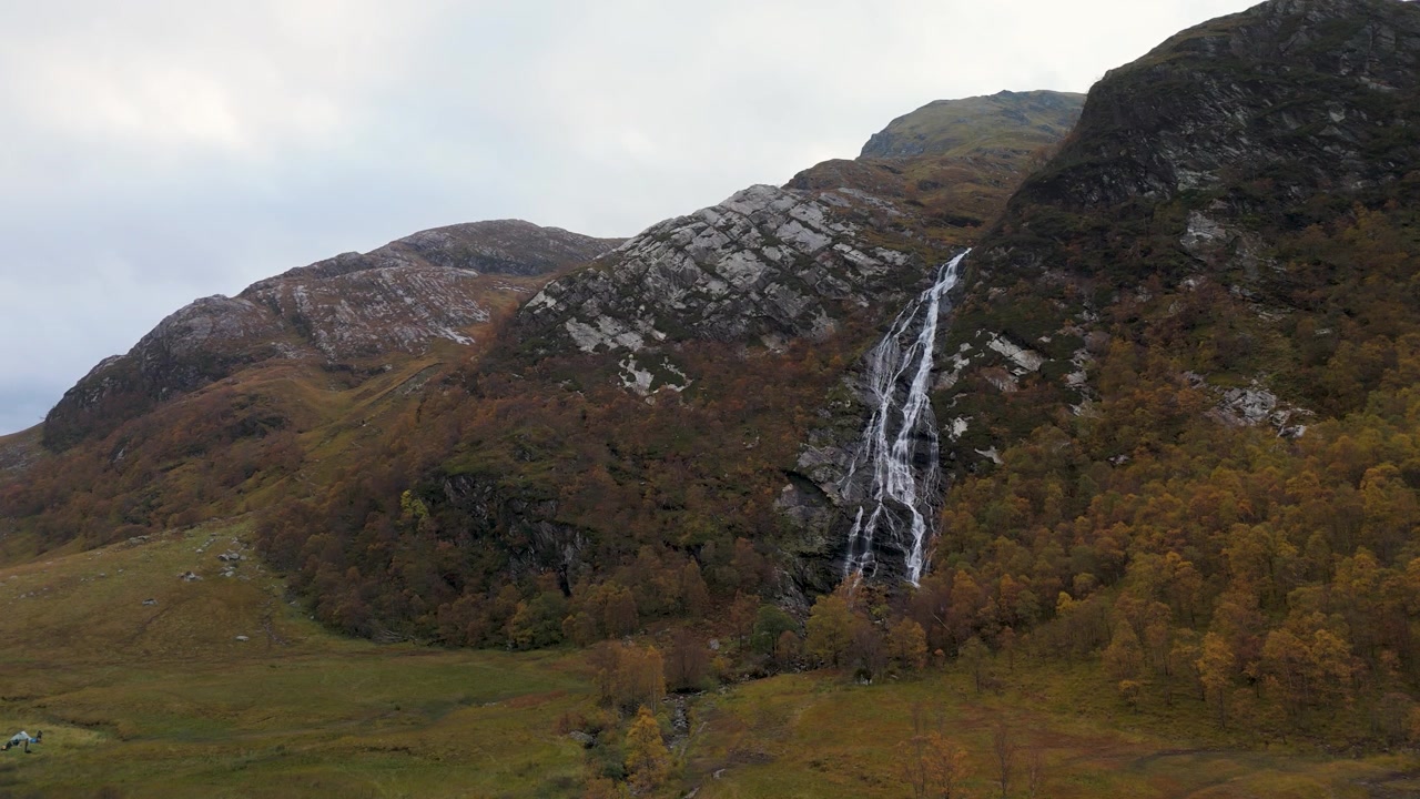 Ampia veduta delle cascate di Steall che scendono a cascata attraverso un bosco autunnale, ideale per i viaggi