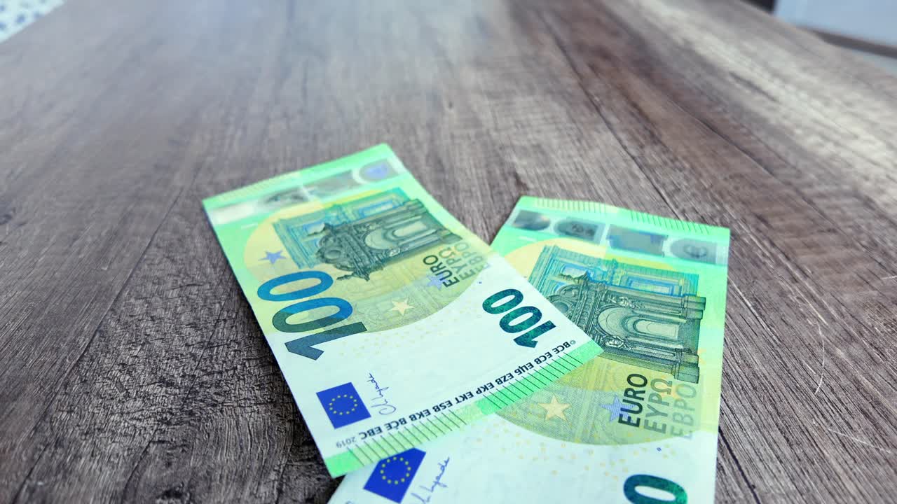 100 eurosedler falder på bordet, penge flyver, og rigdom