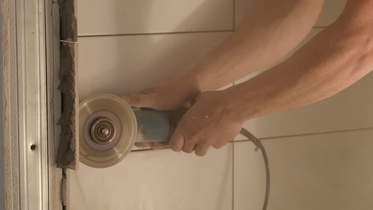Cutting a wall with an angle grinder in a bathroom renovation