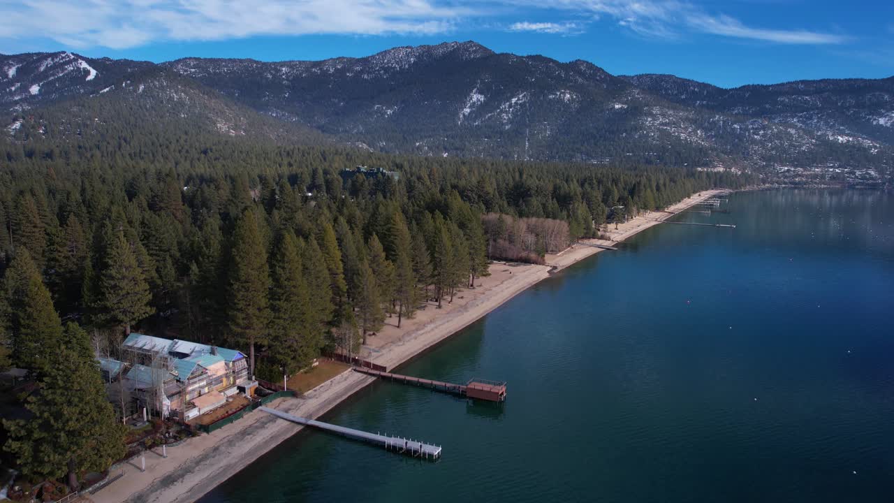 vista aérea de la pintoresca costa del lago tahoe, estados unidos, aguas tranquilas, bosque de pinos, colinas y edificios frente al mar