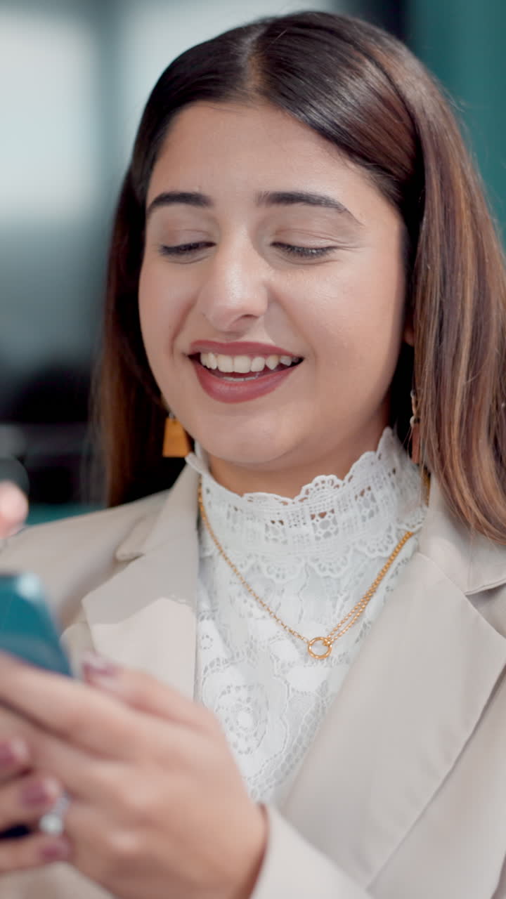 Giovane donna sorride e ride mentre usa il suo smartphone
