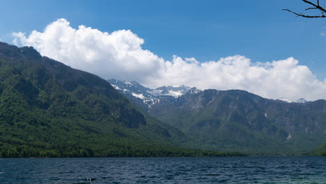 time-lapse-of-white-fluffy-clouds-forming-over-Lake-Bohinj,-Slovenia,-between-mountain-range-in-Trigav-National-Park