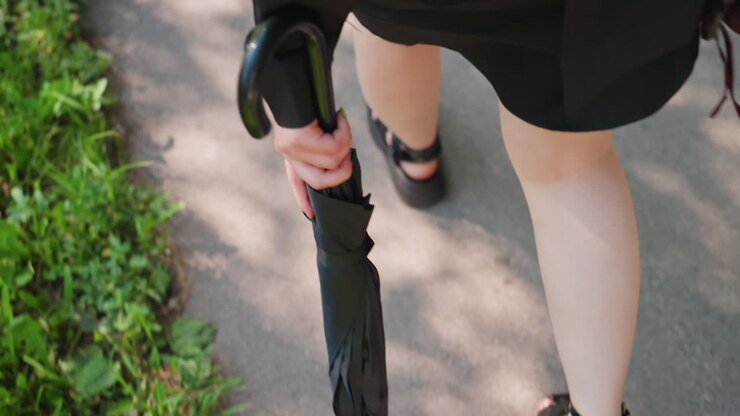lady wandering among verdant trees, woman holding umbrella meanders through lush garden surroundings, lady with umbrella calmly navigates vibrant park environment with abundant plant life