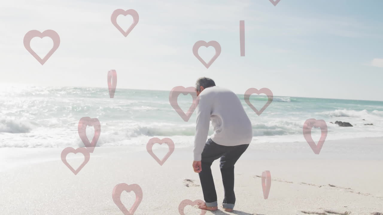 At beach, man relaxing with heart shapes animation overlaying scene