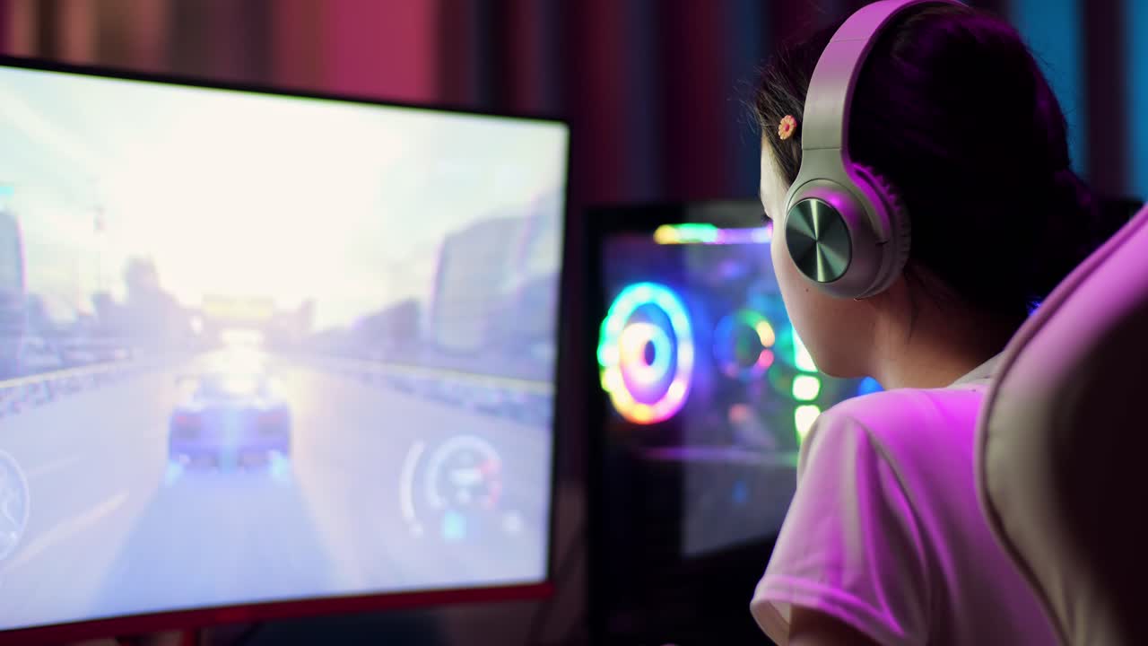 primer plano de una adolescente asiática emocionada que celebra la victoria mientras juega a videojuegos en la computadora, jugando a un videojuego de carreras