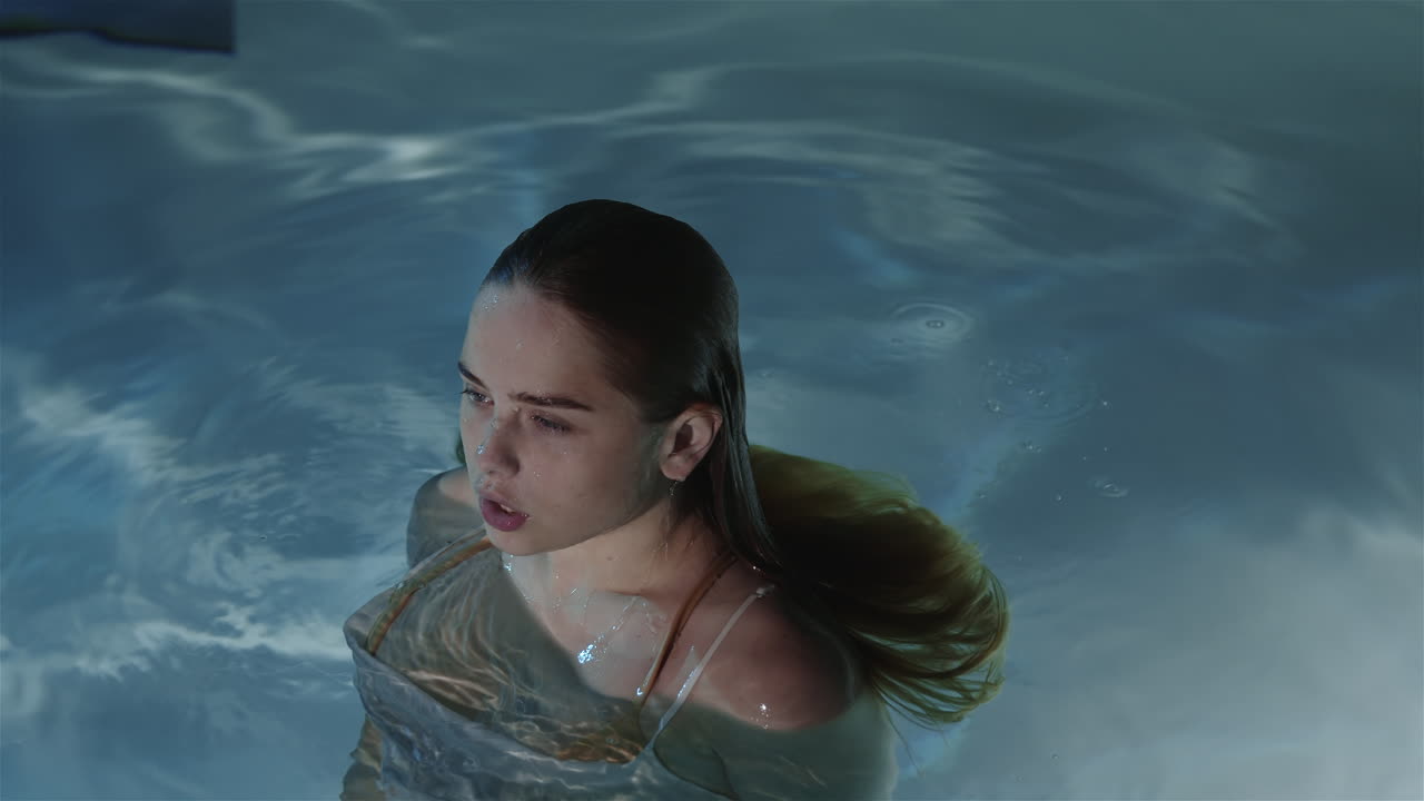 빨간 머리카락을 가진 소녀가 물 밖으로 서서히 나타났습니다.