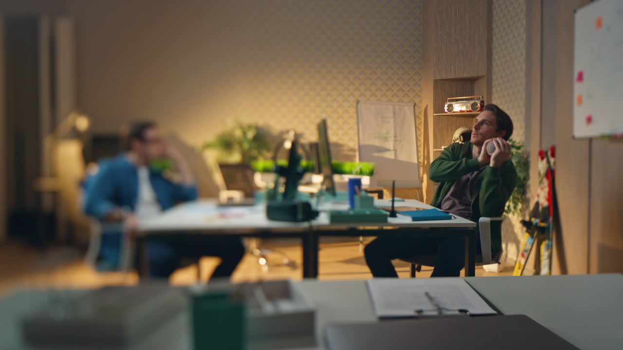 холодные фрилансеры бросают мяч, играют в офис, эффект размытия. человек ловит игрушку.