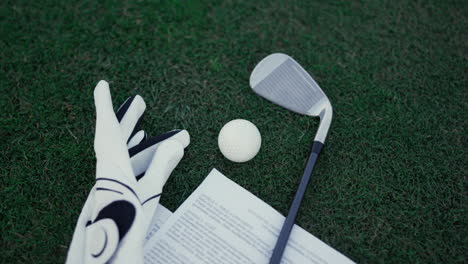 golf sport equipment clubs lying on green grass course fairway filed outdoors.