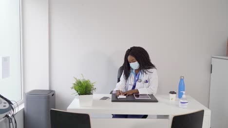 smiling african american doctor writing in notebook