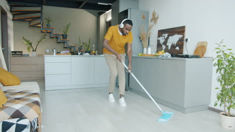 man mopping and dancing in modern kitchen