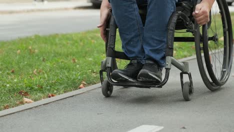 hombre con discapacidad en silla de ruedas camina por el callejón del parque
