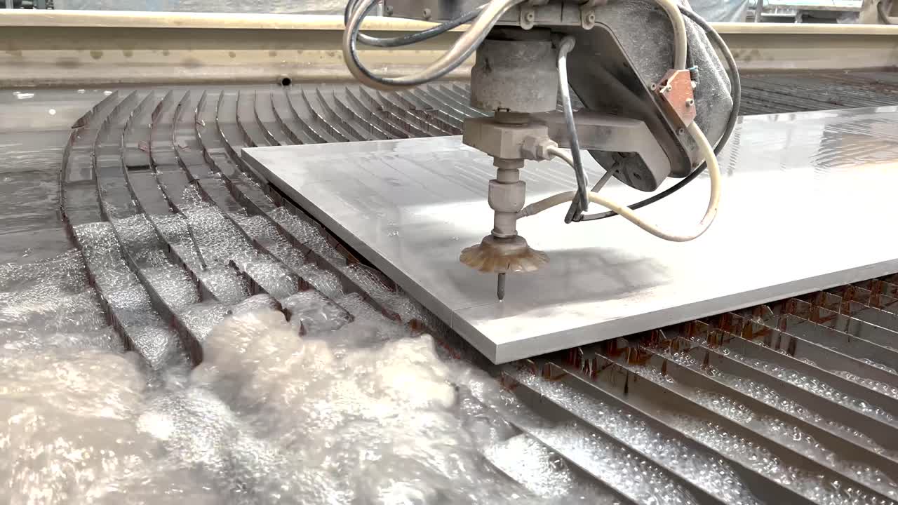 Industrial scene of CNC water jet machine cutting stone slab by water pressure. Stone company