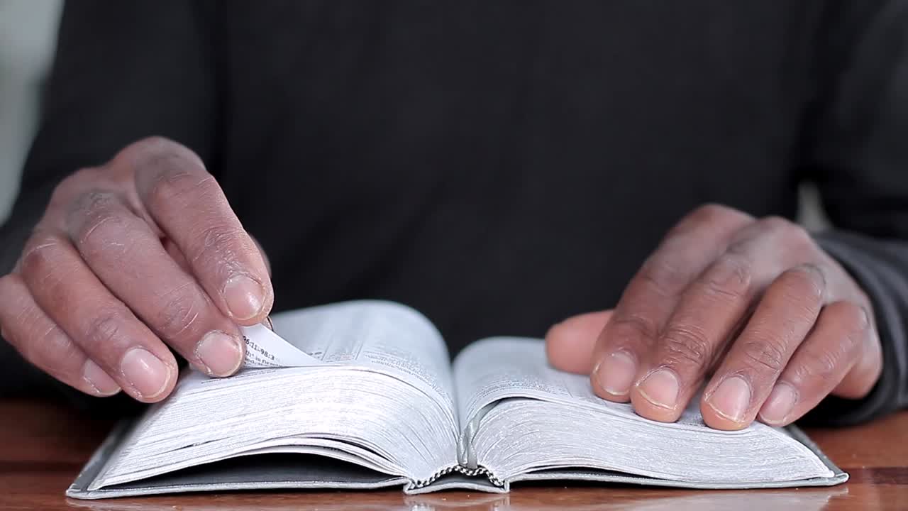 hombre negro orando a dios con la biblia en las manos hombre caribeño orando con el fondo con la gente stock video stock footage