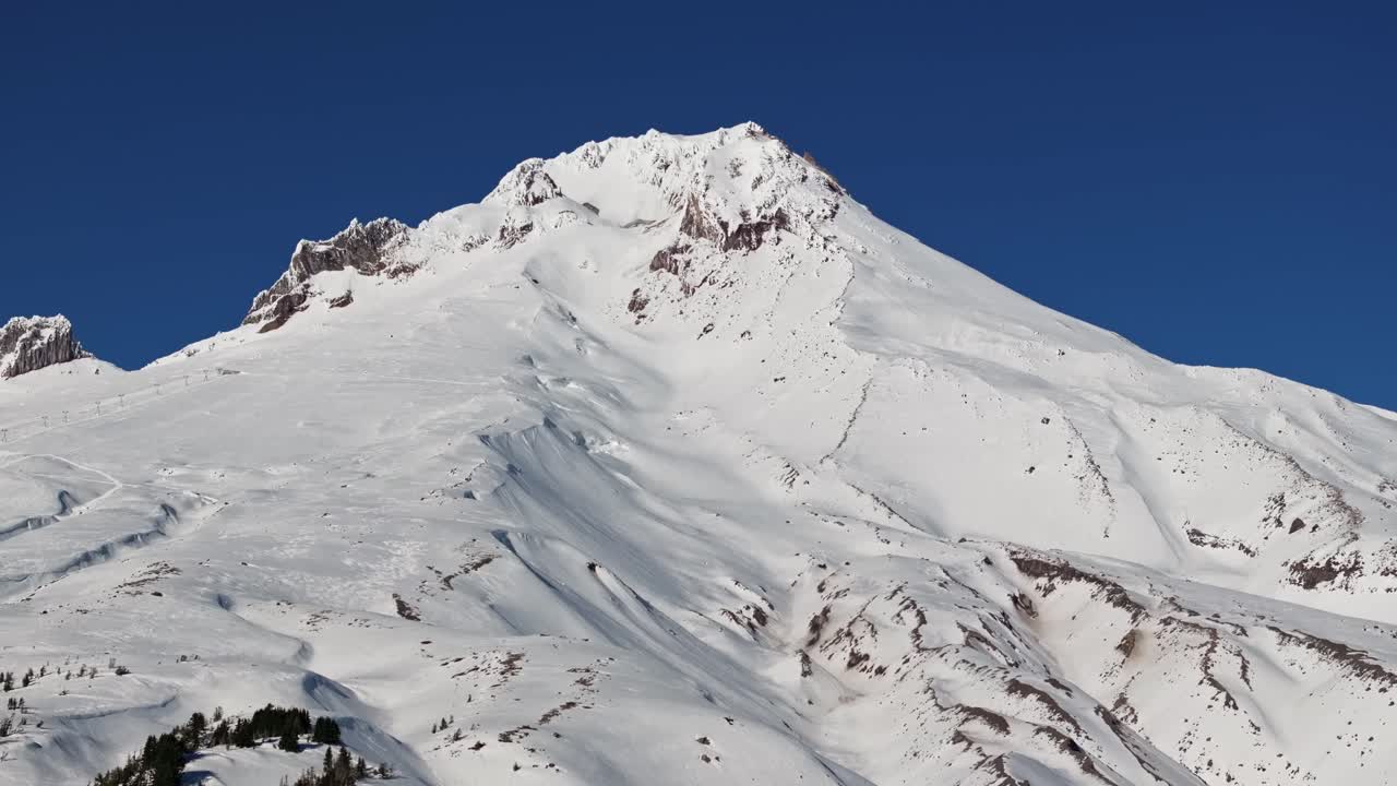Ripresa aerea media con drone di Mount Hood e del suo cratere fumante con ghiacciai e canyon profondi sulla cima del vulcano solitario nel Pacific Northwest, vicino a Hood River e Portland, Oregon.