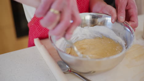 el padre ayuda al hijo a mezclar la masa en un plato de pan